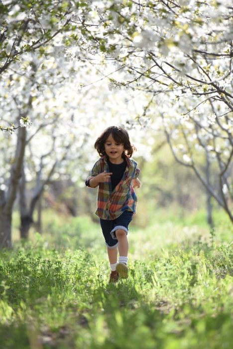 Enfant courant dans la parc lors d'une sortie avec sa nounou