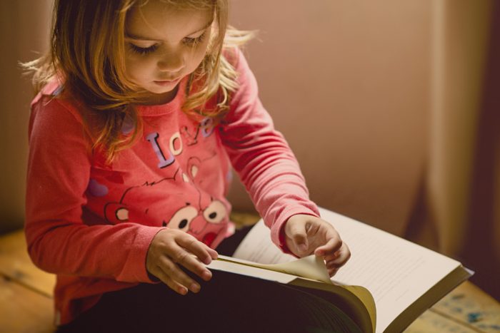 Jeune enfant feuilletant un livre en anglais