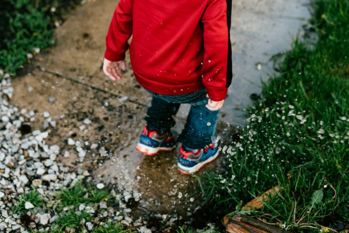 Enfant sautant dans une flaque d'eau en activité plein air