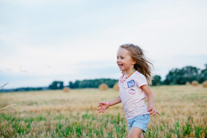 Enfant courant lors d'une sortie nature avec sa nounou